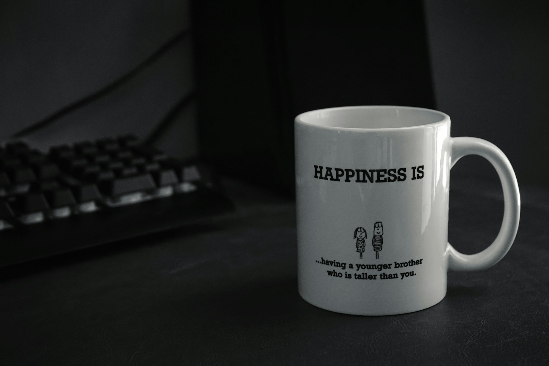 a coffee mug sitting next to a computer keyboard